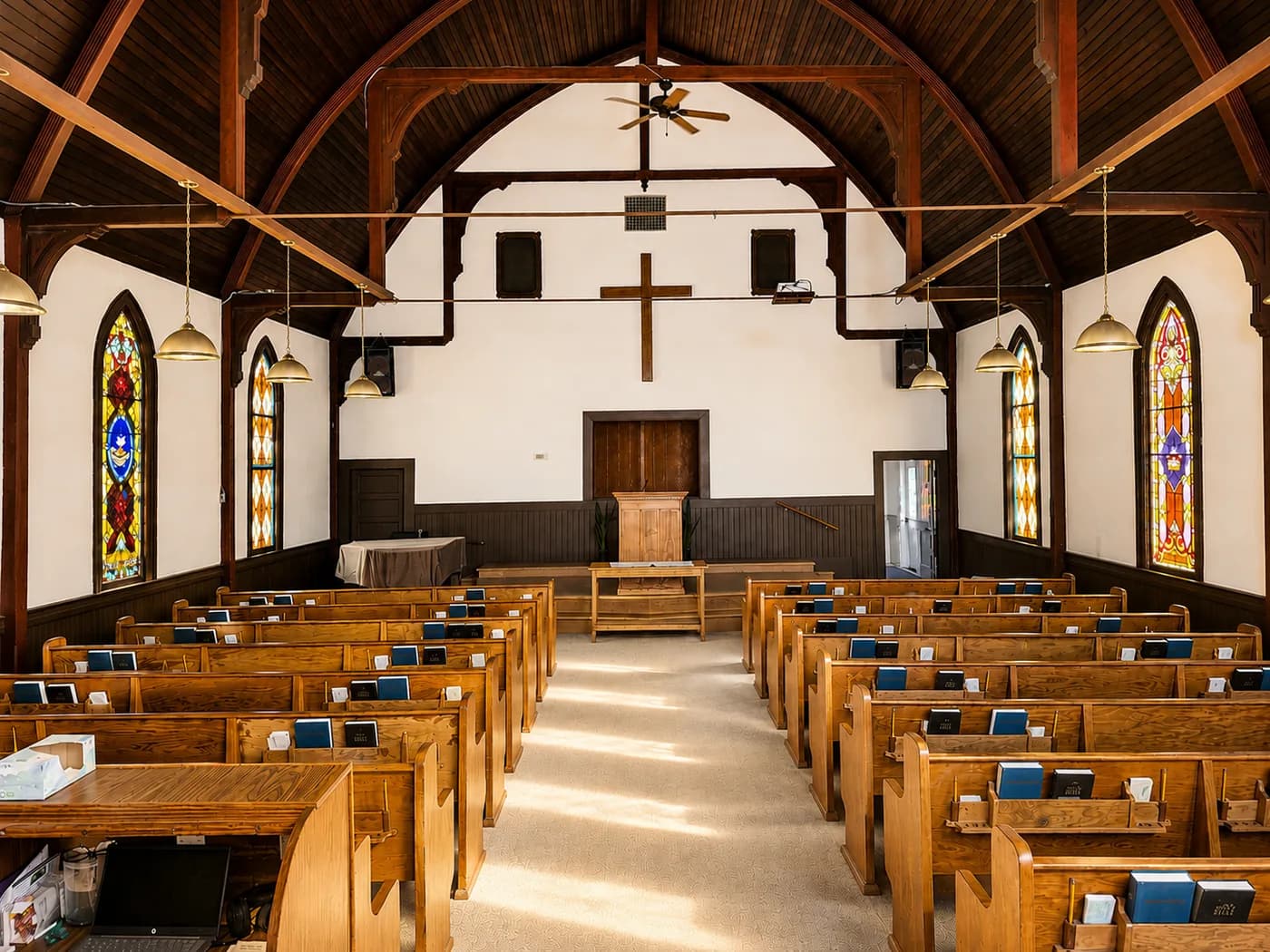 The historic sanctuary of First Baptist Church of Sonoma — wood-beam ceiling, stained glass, and pews
